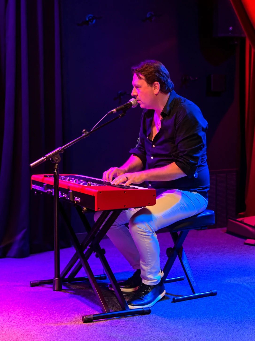 Dan Ennis singing and playing piano during a live performance